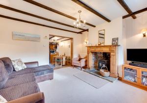 een woonkamer met een bank en een open haard bij Tones Cottage in Great Ryburgh