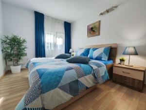 塞尔瑟Apartments Lino的卧室里有一张床，床铺有蓝白相间的被子
