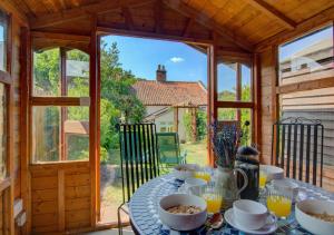 una mesa con comida en una casa de madera en Wren Cottage en Aylsham