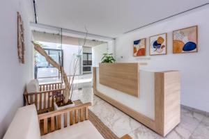 a living room with white walls and a staircase with a wooden counter at Lumina at Cardinal San José del Cabo in San José del Cabo