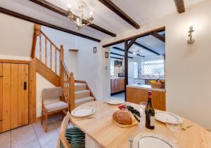 a dining room with a table with a bottle of wine at Tones Cottage in Great Ryburgh