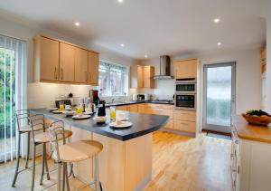 a kitchen with a large island with bar stools at Wyatt House in Norwich