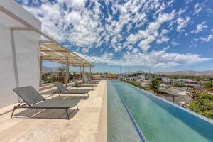 a pool on the roof of a house with lounge chairs at Lumina at Cardinal San José del Cabo in San José del Cabo