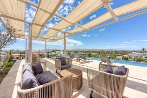 an outdoor patio with couches and chairs and a pool at Lumina at Cardinal San José del Cabo in San José del Cabo