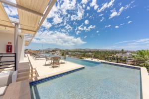 a swimming pool with a table and chairs on a balcony at Lumina at Cardinal San José del Cabo in San José del Cabo