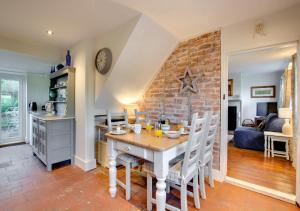 a kitchen and dining room with a table and chairs at Thimble Cottage in Dersingham