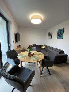 een woonkamer met een bank en een tafel bij Apartament w Dolinie Sanu 2 in Lesko