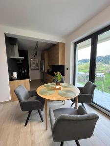 een woonkamer met een tafel en stoelen en een keuken bij Apartament w Dolinie Sanu 2 in Lesko