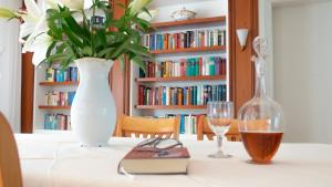 een tafel met een vaas en een boek en een glas bij Haus am Steinberg in Bad Driburg