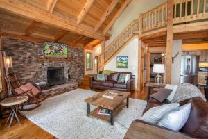 uma grande sala de estar com lareira de pedra em Bald Mountain Lodge em Todd