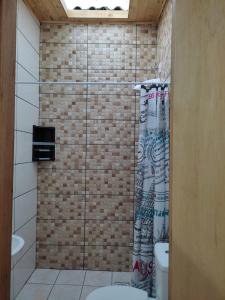 a bathroom with a shower curtain and a toilet at Pousada Brum in Pelotas