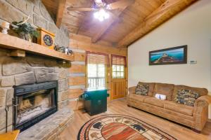 a living room with a stone fireplace and a couch at Gatlinburg Cabin with Hot Tub about 6 Mi to Downtown! in Gatlinburg