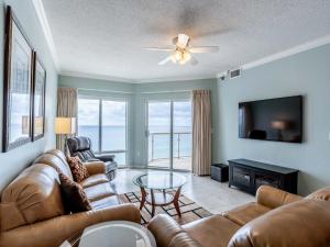 Una sala de estar con un sofá, un televisor y una mesa. en Emerald Isle #1007, en Pensacola Beach