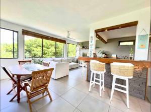 een keuken en een woonkamer met een tafel en stoelen bij Seaview Sunset Apartment in Tamarin