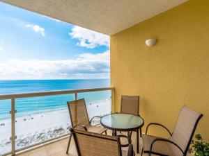 Un balcón con mesa y sillas y la playa. en Emerald Isle #1007, en Pensacola Beach