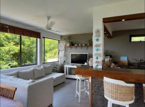 a living room with a white couch and a kitchen at Seaview Sunset Apartment in Tamarin