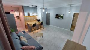 un soggiorno con divano blu e una cucina di Matei Apartments a Baia Mare