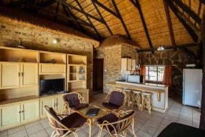 Una cocina con mesa y sillas y un refrigerador. en Inyala Game Lodge, en Ventersdorp