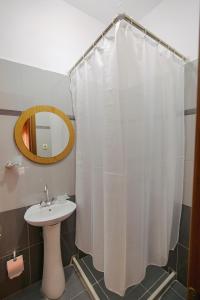 een badkamer met een wastafel en een douchegordijn bij Apartments & Hotel Eleanna in Sarandë