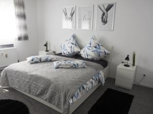 1 dormitorio con 1 cama con almohadas azules y blancas en Ferienwohnung 90 m2 in Sulzbach 2 Minuten Fußweg zum Krankenhaus, en Sulzbach