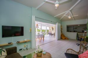a living room with a couch and a tv at Casa Monte Bello in Willemstad