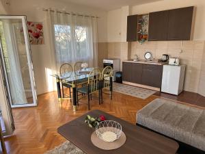 een keuken en een woonkamer met een tafel en stoelen bij Porodični Apartman Igalo in Igalo