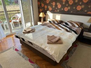 een slaapkamer met een bed met twee handdoeken erop bij Porodični Apartman Igalo in Igalo