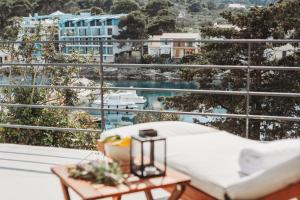 a balcony with a bed and a table with a view at SOL luxury residence near the beach with shared heated pool in Božava