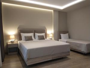 a bedroom with two beds and two lamps in it at Menta in Litochoro