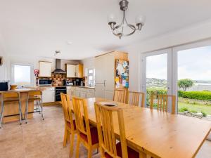 a kitchen and dining room with a wooden table and chairs at Chy-An-Var in Polzeath