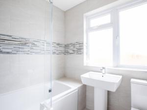 a white bathroom with a sink and a shower at Chy-An-Var in Polzeath