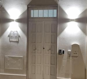 un pasillo con una puerta blanca y dos luces en Il civico storico, en Brindisi