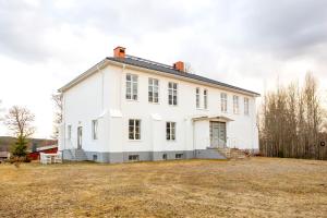 una grande casa bianca su un prato di Vakantievilla Rämmen Skola a Rämmen