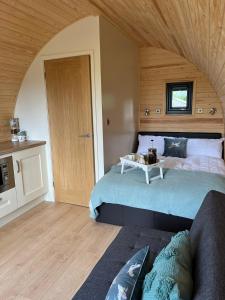 a bedroom with two beds and a couch in it at Willow Farm Glamping in Chester