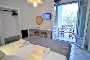 a bedroom with a bed and a balcony with a table at George in Galissas