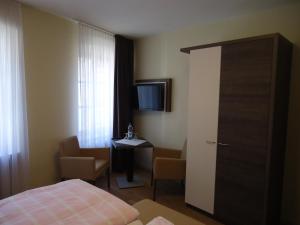 a hotel room with a bed and a table and a television at Hotel Gasthaus Huwer in Bernkastel-Kues
