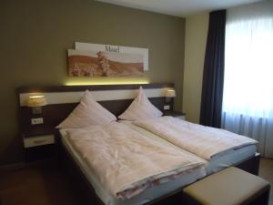 a bedroom with a bed with pillows on it at Hotel Gasthaus Huwer in Bernkastel-Kues