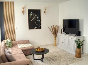 uma sala de estar com um sofá e uma televisão em NIVI Apartment em Split