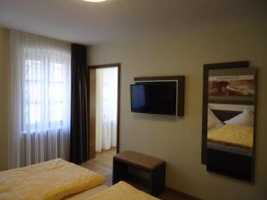 a hotel room with two beds and a flat screen tv at Gasthaus Huwer in Bernkastel-Kues