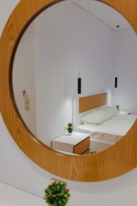 a mirror reflection of a bedroom with a bed at Hotel Eleana & Apartments in Sarandë