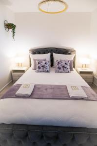 um quarto com uma cama grande e almofadas roxas em Aquarius Residence Apartament 104 em Boszkowo