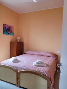 a bedroom with a bed with two towels on it at Ocean View Flat with WI-FI, AC and Elevator to Town in Levanto