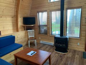 uma sala de estar com um fogão a lenha numa cabina em Oyster Bay Resort em Oyster Bay