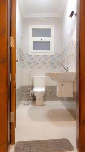 a small bathroom with a toilet and a sink at شقة للإيجار المفروش المدد القصير بكمبوند سما القاهرة. in Cairo