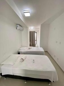 um quarto de hospital com duas camas e uma janela em DUPLEX com Hidromassagem total de 02 QUARTOS e Vista MAR em Aracaju