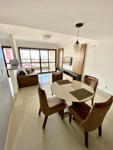 een woonkamer met een tafel en stoelen en een bank bij DUPLEX com Hidromassagem total de 02 QUARTOS e Vista MAR in Aracaju