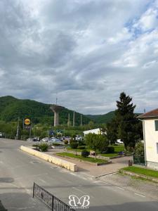 an empty street with a mountain in the background at B&B Apartment in Oţelu Roşu