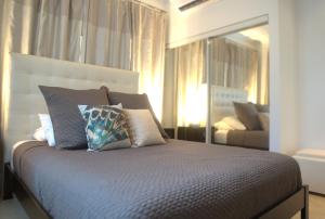ein Schlafzimmer mit einem Bett mit Kissen und einem Sofa in der Unterkunft Diamante 165 Luxury Villa with Private Pool in Gold Coast 3 Bedrooms 3 Bath in Palm-Eagle Beach