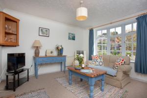 a living room with a couch and a tv at Orchard Cottage in Sidmouth