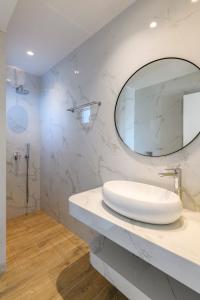a white bathroom with a sink and a mirror at Blueisla Sea View Suite A in Mikonos +13 photos